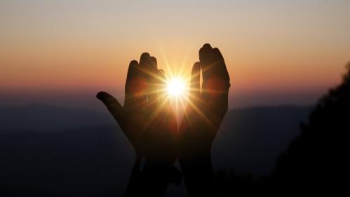 spiritual prayer hands sun shine with blurred beautiful sunset