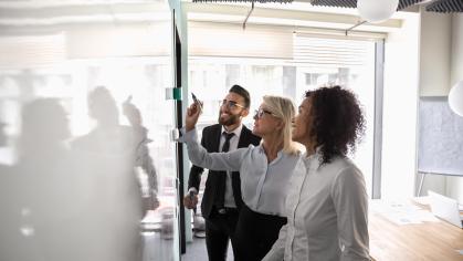 Colleagues writing on white board