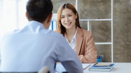 Man in wheelchair speaking to colleague