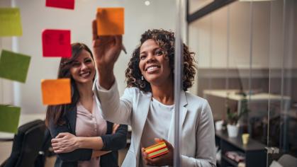 Woman placing sticky notes on a glass wall