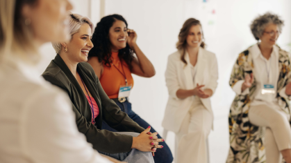 Women sitting in a circle, speaking and reacting to others