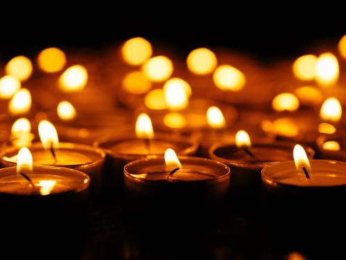 Picture of a group of lit candles against a dark background
